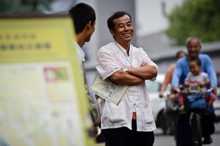 Cao Junlai conversa con otros conductores de rickshaw en la zona de Shichahai de Pekín, el 12 de septiembre de 2014.