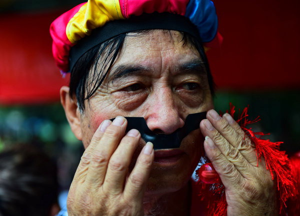 Chen Bin, de 73 a?os, comprueba su maquillaje antes de una presentación de baile. [Foto: PPC]