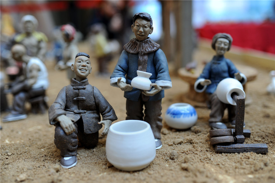 Estatuillas de?unos?artesanos vendiendo porcelana en la calle?hechas de arcilla.?[Fotografía?por?Wang?Haibin/Asianewsphoto]