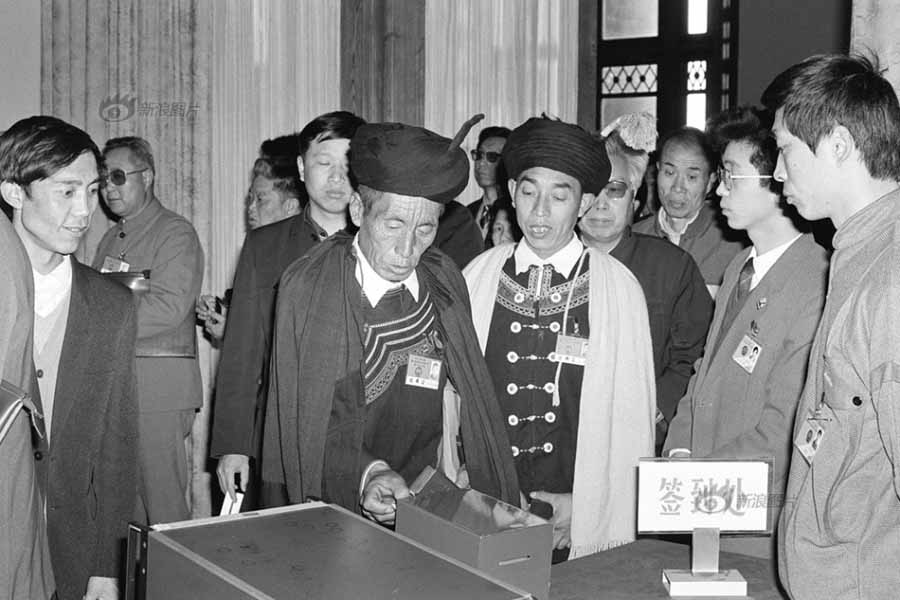 Foto tomada en 1989 muestra al personal de apoyo de las Dos Sesiones coordinando la firma de los diputados. [Fotografía: Tang Mengzong/Xinhua]