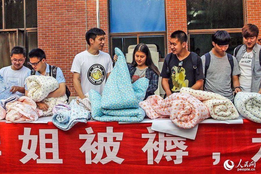 Long Yi monta un puesto de edredones junto al dormitorio de la universidad, el 31 de mayo de2015. (Foto/Pueblo en Línea)