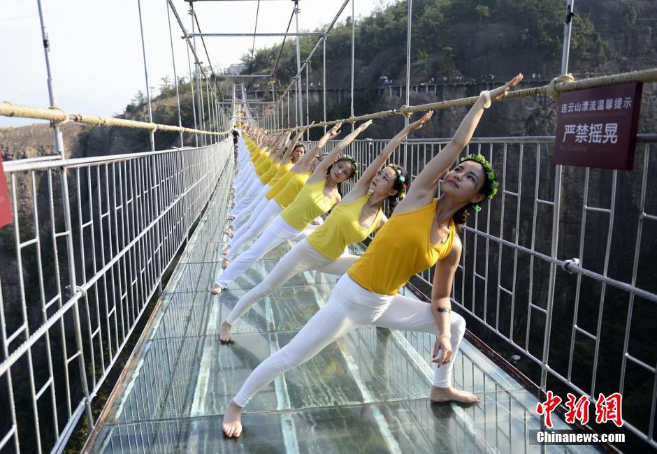 100 hermosas jóvenes practican Yoga en un puente de cristal