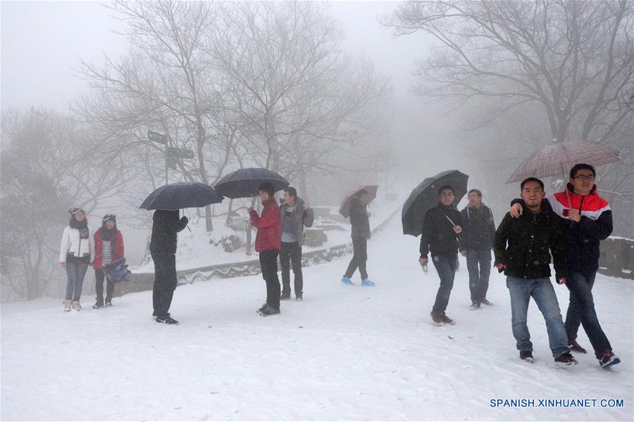 Gente escalan una monta?a en la nieve en Nanjing, capital de la provincia de Jiangsu, este de China, enero 22, 2016. La estación central Meteoical emitió alerta amarilla para el brote de aire frío viernes. (Xinhua / Wang Yuewu)