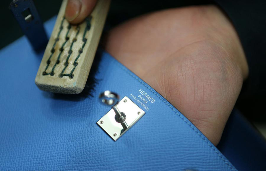 Un trabajador limpia un bolso en Chengdu, capital de la provincia de Sichuan, el 23 de marzo de 2016. 