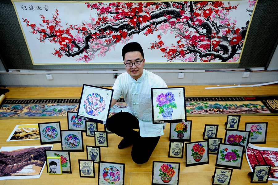 Zhao Congzhuo, posa con unos recortes de papel en Shenyang, provincia de Liaoning, el 19 de abril de 2016. [Foto/VCG]