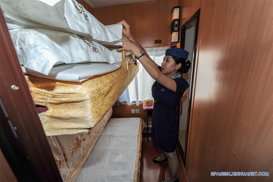  HELONGJIANG, mayo 31, 2016 (Xinhua) -- Una conductora hace la cama en un vagón de un tren turístico que corre de Harbin a Heihe, provincia de Helongjiang, en el noroeste de China, el 31 de mayo de 2016. Para satisfacer las necesidades de los turistas, la administración del ferrocarril de Heilongjiang abrió una nueva línea turística de Harbin a Heihe e invitó el martes a algunas personas a experimentar la línea. (Xinhua/Wang Song)