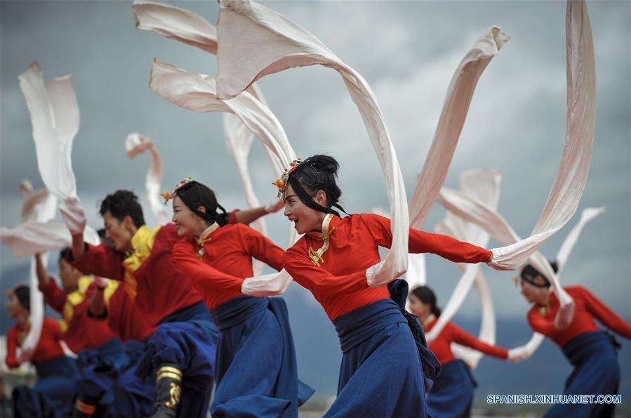 Personas interpretan un baile tradicional durante un festival de carreras de caballos en Shangri-la, Prefectura Autónoma Tibetana de Diqing, en la provincia de Yunnan, en el suroeste de China, el 9 de junio de 2016. Un total de 194 caballos participarán en el festival étnico tradicional de tres días de duración, que dio inicio el jueves. (Xinhua/Zhou Lei)