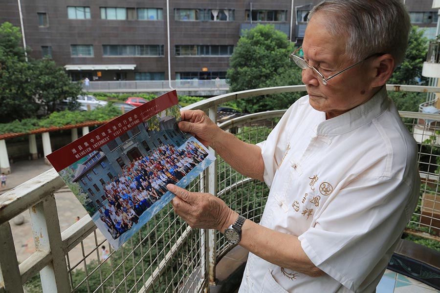 Wang mira la foto de los internados que él ayudó a liberar hace 71 a?os. [Fotografía de Jun/chinadaily.com.cn Yang]