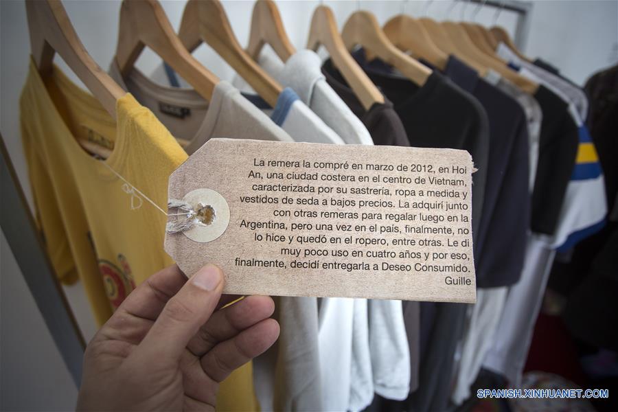 Imagen del 9 de septiembre de 2016 de una persona sosteniendo un texto escrito con la historia de la prenda donada para la exposición "Salí del Placard", que es parte del proyecto Deseo Consumido, en el espacio Hiedra, en el barrio Chacarita, en Buenos Aires, capital de Argentina. Las periodistas Soledad Vallejos y Evangelina Himitian, junto con la artista plástica Fernanda Díaz explicaron que el proyecto Deseo Consumido se propone cuestionar y cuestionarse el consumismo, a partir de que las dos amigas periodistas decidieron pasar un a?o sin comprar nada más allá de lo necesario para alimentarse y asearse. Las periodistas pidieron a la artista plástica que les ayudara a organizar artísticamente esta experiencia y de ello nació la exposición "Salí del Placard", donde se exhiben objetos en desuso, especialmente aquellos que se guardan en un armario como la ropa, junto con la investigación, la escritura y los pensamientos surgidos durante la realización de todo el proyecto. La intervención nace a partir de la idea de que sus experiencias se transmitan con otro lenguaje, para promover la conciencia sobre del impacto social y ambiental del consumo. Durante la exhibición, que se llevará a cabo hasta el 15 de septiembre, se invita a los visitantes a dejar sus propios objetos en desuso.(Xinhua/Martín Zabala)