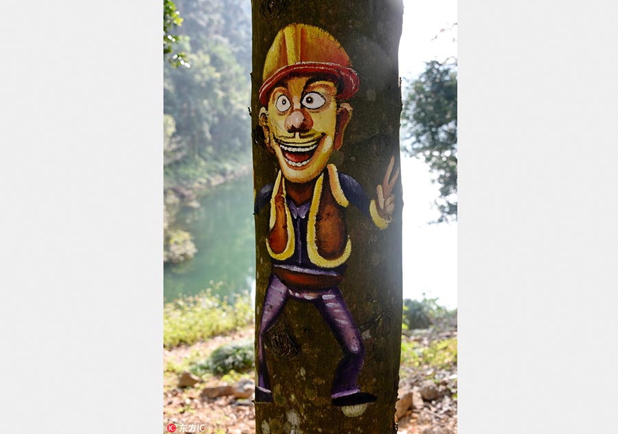 Pintura divertida de un personaje de dibujos animados en un árbol en el condado de Shangyou, provincia de Jiangxi. [Foto / VCG]