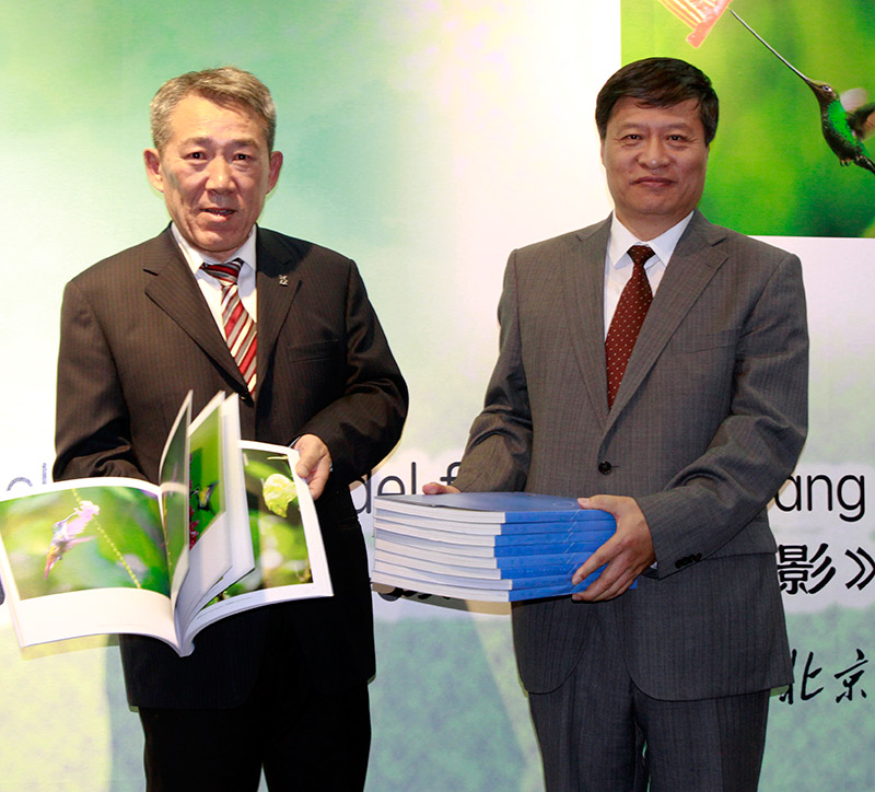 El fotógrafo Wang Jianguo entrega ejemplares del libro "Aves silvestres del Ecuador" al Dr. Meng Qingjin, director del Museo de Historia Natural de Beijing. (Foto: YAC)