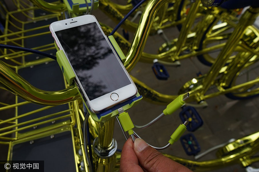 Un usuario carga su teléfono en una bicicleta compartida Coolqi en Beijing, el 8 de junio de 2017. [Foto / VCG]