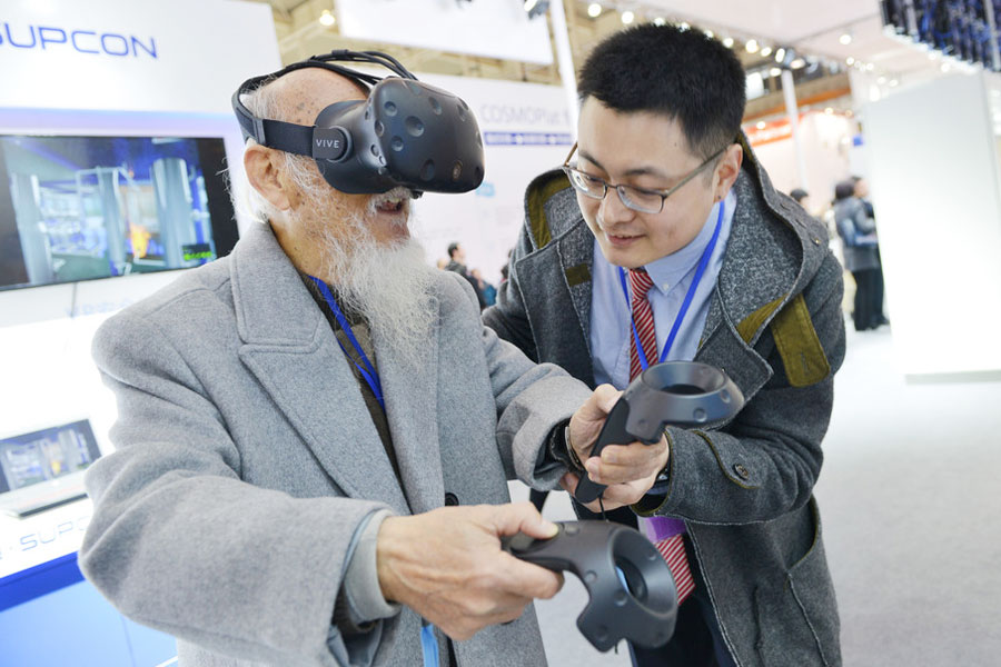 Una persona de unos 90 a?os prueba la tecnología de realidad virtual en la Cumbre Mundial de Fabricación Inteligente en Nanjing, provincia de Jiangsu, el 6 de diciembre de 2017. [Foto / IC]