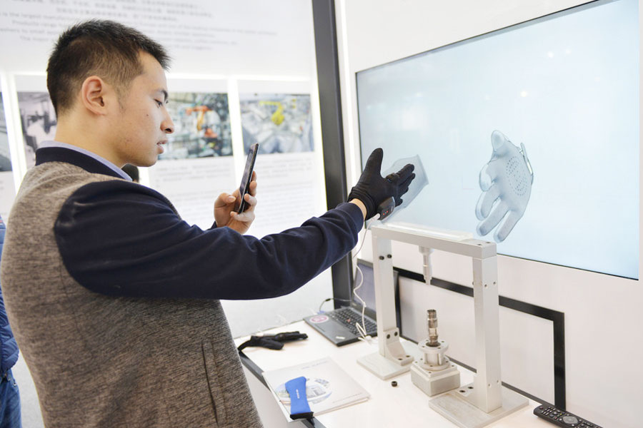 Un hombre prueba un guante inteligente en la Cumbre Mundial de Fabricación Inteligente en Nanjing, provincia de Jiangsu, el 6 de diciembre de 2017. [Foto / IC]