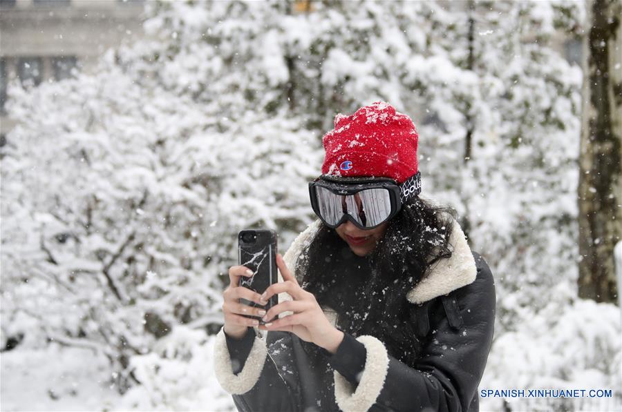 Una mujer toma fotografías bajo la nevada en Madison Square Park en Nueva York, Estados Unidos, el 21 de marzo de 2018. Miles de vuelos fueron cancelados y escuelas públicas cerradas mientras la cuarta tormenta de nieve en tres semanas comenzó a golpear el miércoles la ciudad de Nueva York y sus áreas vecinas, de acuerdo con información de la prensa local. (Xinhua/Wang Ying)