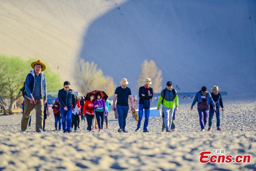 Los turistas visitan las monta?as arenosas cantantes de Dunhuang 