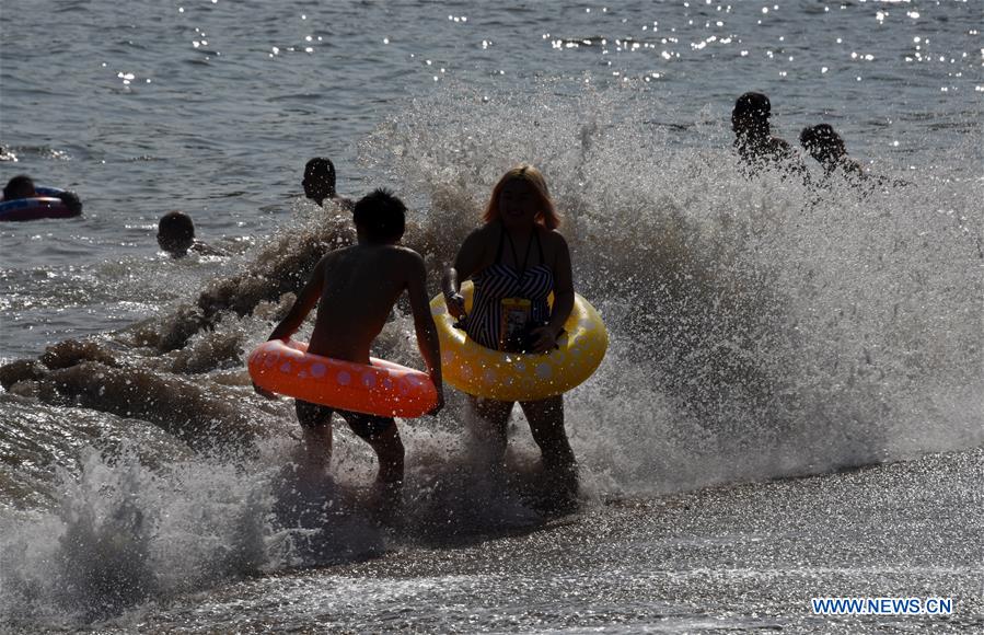 La gente juega en el balneario de Qingdao, E Shandong de China