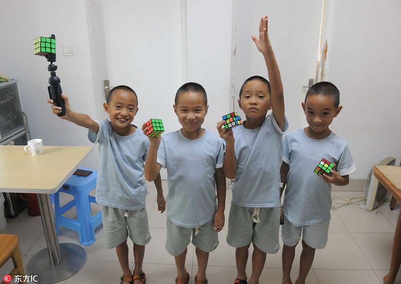 Las cuatrillizos posan con un cubo de Rubik. [Foto: IC]