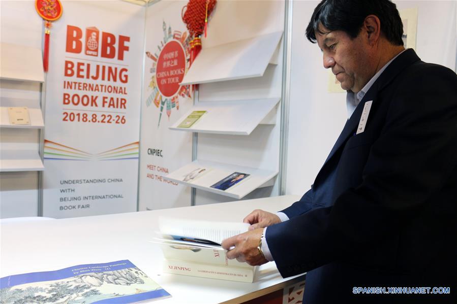 Imagen del 9 de agosto de 2018 de una persona hojeando el segundo volumen del libro escrito por el presidente de China, Xi Jinping, "Xi Jinping: La Gobernación y Administración de China" en el estand "Pabellón Rojo" de la Feria Internacional del Libro (FIL) de La Paz 2018, en La Paz, Bolivia. En el "Pabellón Rojo" de la Feria Internacional del Libro (FIL) de La Paz 2018 se instala un puesto, donde China, con la distinción de "Invitado Destacado", ocupa un lugar sobresaliente en la exposición que inició el pasado 1 de agosto y se extenderá hasta el domingo 12 de agosto. (Xinhua/René Quenallata)