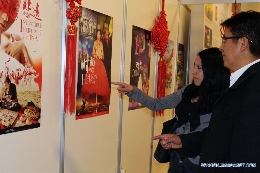 Imagen del 9 de agosto de 2018 de personas observando una exhibición de una serie de láminas referentes a la cultura china, en la parte posterior del estand "Pabellón Rojo" de la Feria Internacional del Libro (FIL) de La Paz 2018, en La Paz, Bolivia. En el "Pabellón Rojo" de la Feria Internacional del Libro (FIL) de La Paz 2018 se instala un puesto, donde China, con la distinción de "Invitado Destacado", ocupa un lugar sobresaliente en la exposición que inició el pasado 1 de agosto y se extenderá hasta el domingo 12 de agosto. (Xinhua/René Quenallata)