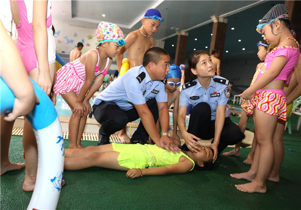 Oficiales de policía ense?an a los ni?os cómo resucitar a un ahogado, Zhengzhou, provincia de Henan. (Foto: Liu Shutting/ China Daily)