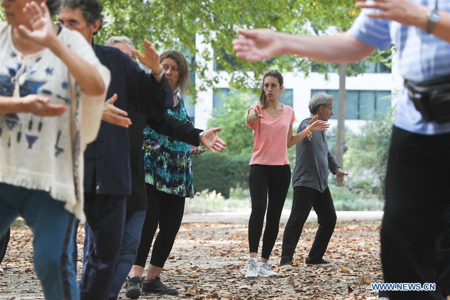 Personas aprenden Tai Chi en el Parque del Cincuentenario en Bélgica