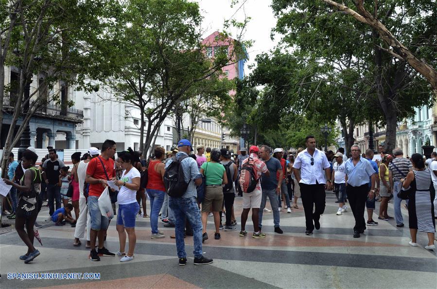 LA HABANA, octubre 7, 2018 (Xinhua) -- Imagen del 6 de octubre de 2018, de personas visitando la Bolsa de Permuta de Prado, en La Habana, Cuba. La conocida Bolsa de Permuta de Prado es un espontáneo lugar de intercambio de casas ubicado en el Paseo del Prado, una de las más viejas avenidas de la capital cubana. Allí, bajo la sombra de frondosos árboles, cientos de personas se dan cita todos los fines de semana en un informal mercado de viviendas donde, con carteles escritos a mano, muchos promueven los inmuebles que ofrecen y lo que necesitan. Los llamados "corredores de permutas" o "permuteros", como también se les conoce popularmente, son personas que se dedican a gestionar los intercambios de vivienda y cobran por esos servicios una parte del dinero involucrado en la transacción. (Xinhua/Joaquín Hernández)