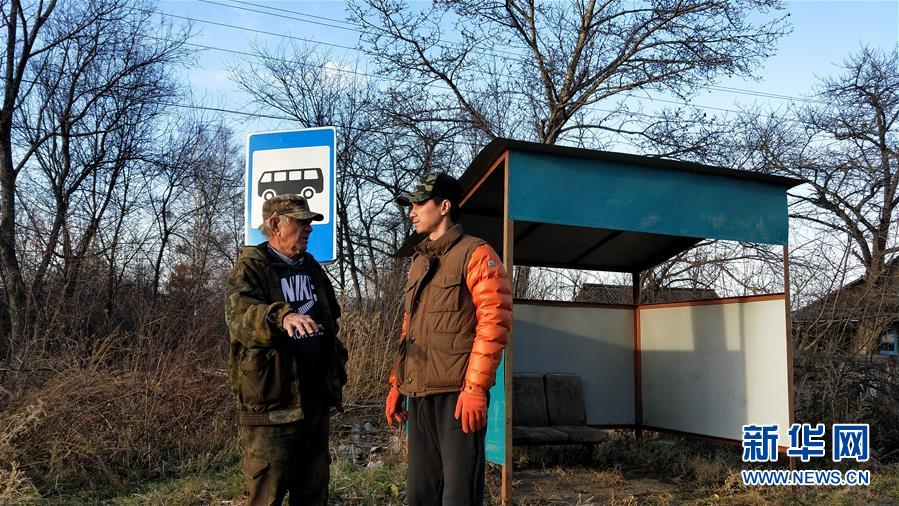 El jefe de la aldea Sasha (izquierda) y Ying Junfeng hablan en la estación de autobuses recientemente renovada (foto tomada el 19 de octubre). Agencia de Noticias Xinhua, reportero Zhang Ruoxuan.