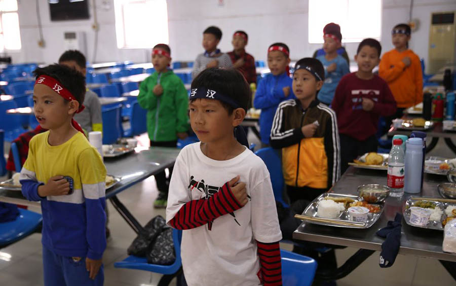 Los ni?os juran ser "hombres de verdad" durante una sesión en el club. [Foto por Zou Hong / China Daily]