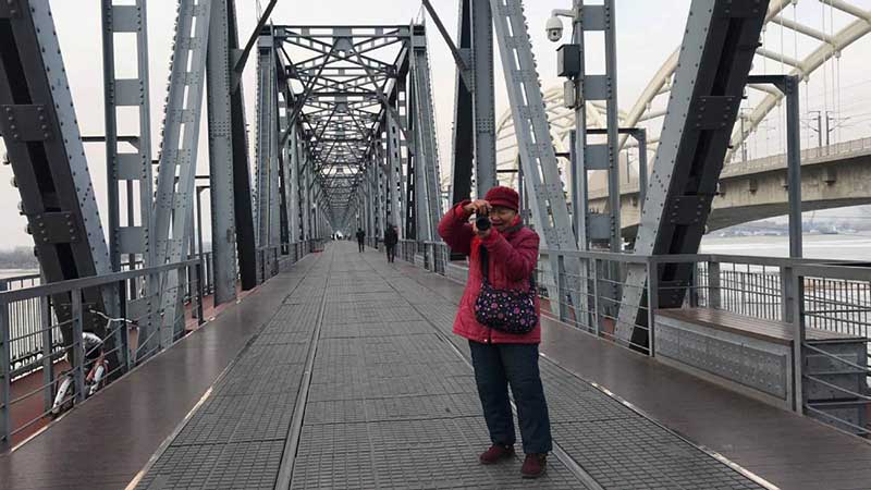 Zhang Ying, de 93 a?os, toma fotos con su mini cámara digital a la orilla del río Songhua en Harbin, capital de la provincia de Heilongjiang, 14 de diciembre del 2018. [Foto: Wang Kun/ Chinadaily.com.cn]