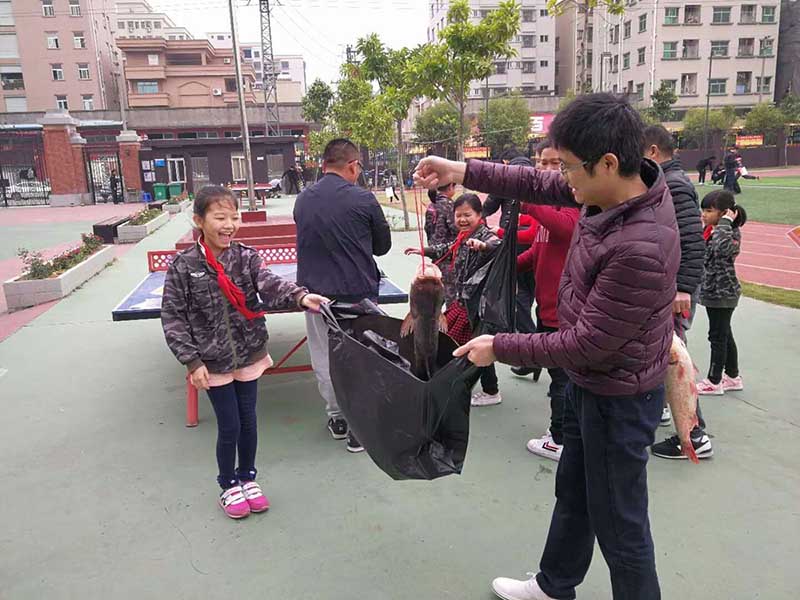 Una ni?a recibe una carpa por sus resultados académicos en la escuela de idioma Wellton, Dongguan, provincia de Guangdong. [Foto: proporcionada a chinadaily.com.cn]