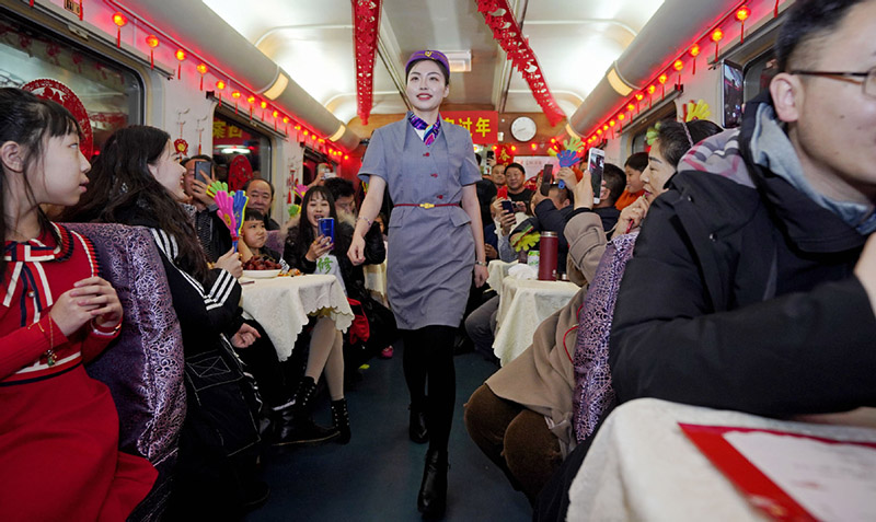 Un asistente de tren modela su uniforme en un tren de Qiqihar, provincia de Heilongjiang, camino a Beijing. Los miembros del personal organizaron una peque?a Gala del Festival de la Primavera para entretener a los pasajeros, muchos de ellos en camino a reunirse con sus familiares, 26 de enero del 2019. [Foto: Cai Yang/ Xinhua]