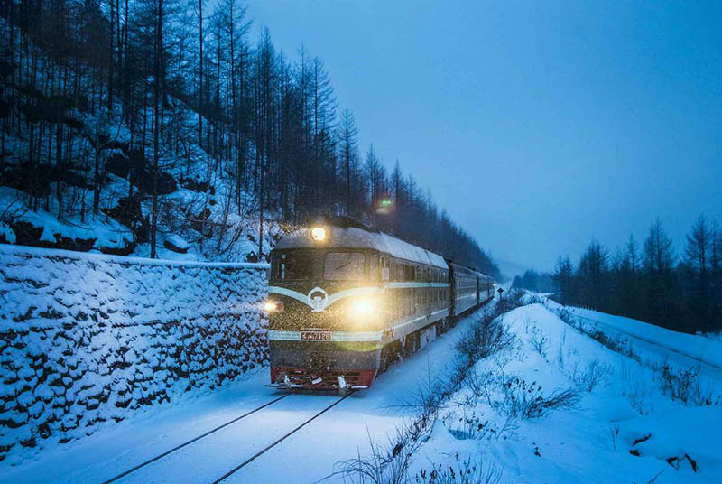 Un tren circula por la nieve en el área de las monta?as del Gran Khingan, en la provincia de Heilongjiang del noreste de China, en enero de 2016. [Foto de Wang Tiancheng / para chinadaily.com.cn]