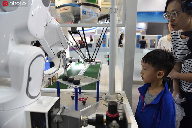 Un ni?o aprende cómo trabaja un robot en la Expo Central China 2019 en Nanchang, en la provincia de Jiangxi, 19 de mayo del 2019. [Foto: IC]