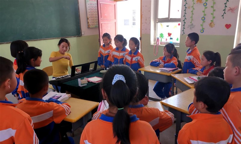 Song Juanli ense?a a cantar a los alumnos de la Escuela Primaria Shanwang. (Foto: China Daily)