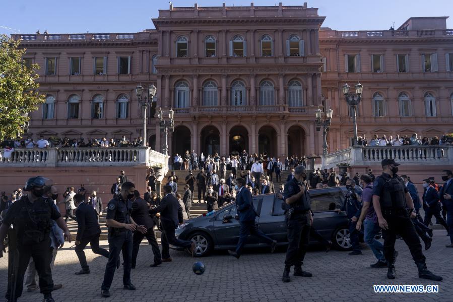 Elementos de la Policía Federal custodian la carroza fúnebre que traslada el féretro de Diego Armando Maradona, frente a la Casa Rosada, en Buenos Aires, capital de Argentina, el 26 de noviembre de 2020. El cortejo fúnebre con los restos de la leyenda argentina del fútbol, Diego Armando Maradona, partió el jueves desde la Casa Rosada rumbo al cementerio donde se realizará la inhumación. (Xinhua/Martín Zabala)