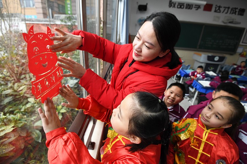 El 30 de diciembre, en la escuela primaria Huaguoyuan No. 3 del distrito Nanming, ciudad de Guiyang, provincia de Guizhou, los maestros ense?aron a los estudiantes a colocar recortes de papel con temática del "buey" del zodíaco chino en el aula. Zhao Song / Pueblo en Línea