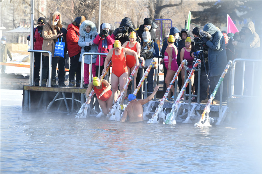 Los entusiastas de la natación de invierno se sumergen en el lago helado de Nanhu para expresar buenos deseos para el nuevo a?o en Changchun, provincia de Jilin, el viernes. [Foto proporcionada a chinadaily.com.cn]