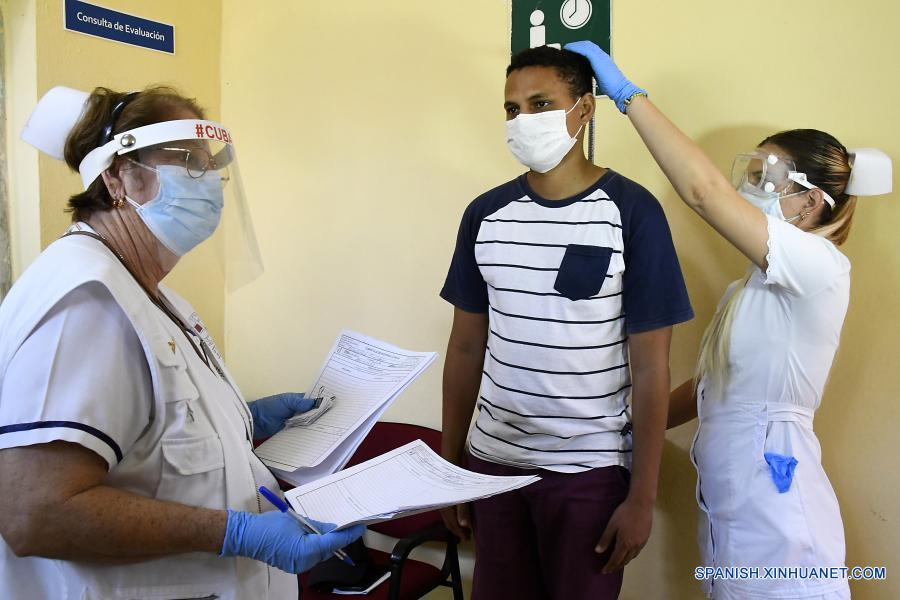 Imagen del 28 de enero de 2021 de médicos examinando a un voluntario para su inclusión en los ensayos clínicos del candidato vacunal contra la enfermedad causada por el nuevo coronavirus (COVID-19), Soberana-02, en el Policlínico 19 de Abril, en el municipio de Plaza de la Revolución, en La Habana, capital de Cuba. Cuba, que en las últimas semanas enfrenta un duro rebrote de la COVID-19, avanza en los ensayos clínicos del candidato vacunal Soberana-02. (Xinhua/Joaquín Hernández)