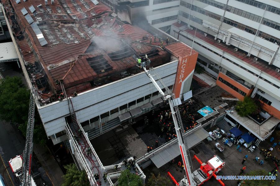 Imagen tomada con un dron de bomberos combatiendo un incendio en el Hospital San Borja, en Santiago, capital de Chile, el 30 de enero de 2021. La Oficina Nacional de Emergencia de Chile reportó el sábado un incendio en el Hospital San Borja, ubicado en el centro de la capital, que obligó a evacuar a pacientes críticos, aunque no se registraron heridos. (Xinhua/Str)