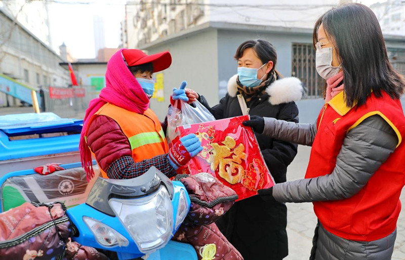 El 1 de febrero de 2021, en la ciudad de Qinhuangdao, los trabajadores comunitarios y los voluntarios donan productos de A?o Nuevo Chino a los limpiadores que no regresarán a sus ciudades natales. (Cao Jianxiong / Pueblo en Línea)