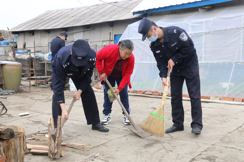 Agentes de policía de la estación de inspección fronteriza de Dadai, condado de Raohe, provincia de Heilongjiang, ayudan a Yu Meili a cortar madera y limpiar el área. [Foto: proporcionada a chinadaily.com.cn]