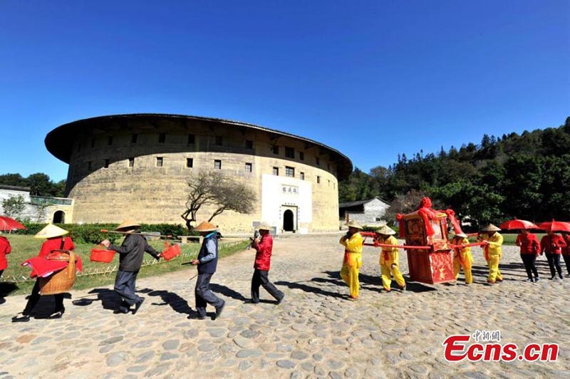 Esta foto sin fecha muestra a personas realizando actividades folclóricas frente a un Tulou en la provincia de Fujian. (Foto / Wang Dongming)