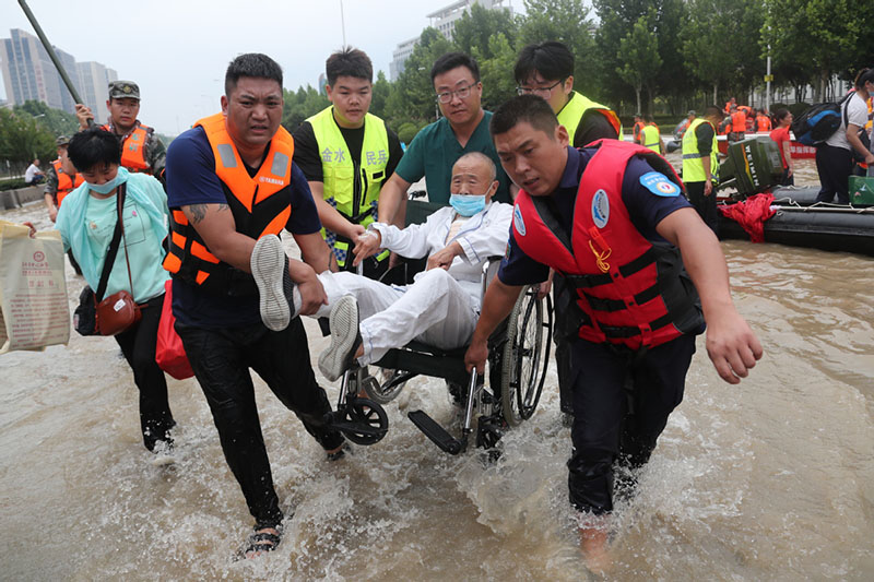 Rescatistas y trabajadores médicos trasladan a pacientes varados en el Hospital Cardiovascular Central de China de Fuwai en Zhengzhou, capital de la provincia central china de Henan, el 22 de julio de 2021. [Foto de Wang Jing / chinadaily.com.cn]