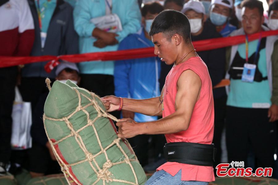 Un competidor levanta una bolsa de arena durante la competición en los séptimos Juegos Deportivos de Minorías étnicas Tradicionales de Qinghai en la ciudad de Haidong, provincia de Qinghai, noroeste de China, el 13 de septiembre de 2021 (Foto: Servicio de Noticias de China / Zhang Tianfu)