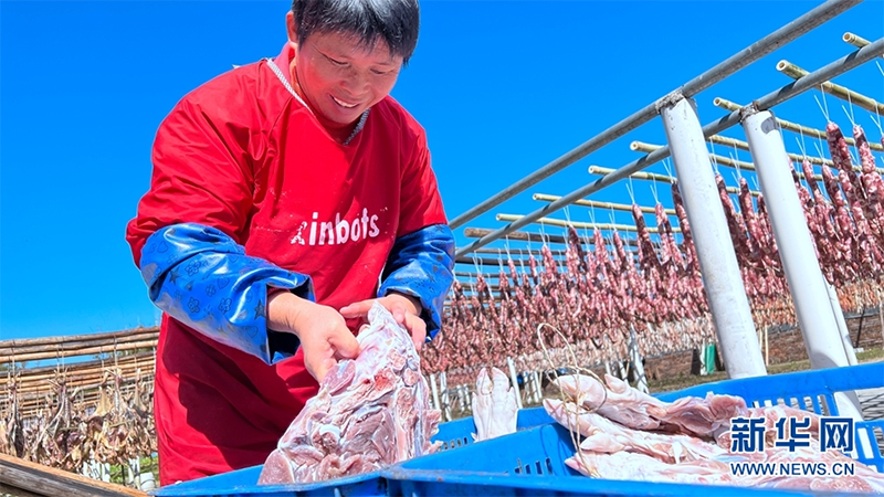 Aldeana cura carne en Lutian. (Foto: Luo Suling)