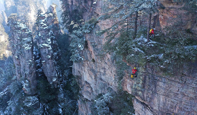 Durante una sesión de entrenamiento, miembros del equipo de rescate de emergencia se ofrecieron como voluntarios para recoger basura en rocas y acantilados del sitio turístico Wulingyuan de Zhangjiajie, provincia de Hunan, febrero del 2022. [Foto: Wu Yongbing/ China Daily]