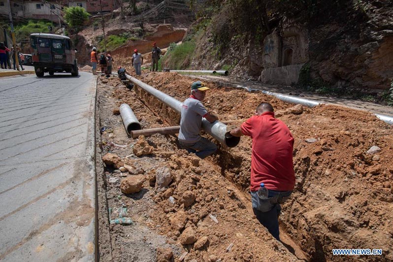  Obreros trabajan en el tendido de una tubería de agua potable en el marco del Día Mundial del Agua en un sector popular de la parroquia La Vega, en el sur de Caracas, Venezuela, el 22 de marzo de 2022. El Día Mundial del Agua se conmemora anualmente el 22 de marzo para recordar la relevancia del vital líquido. (Xinhua/Marcos Salgado)