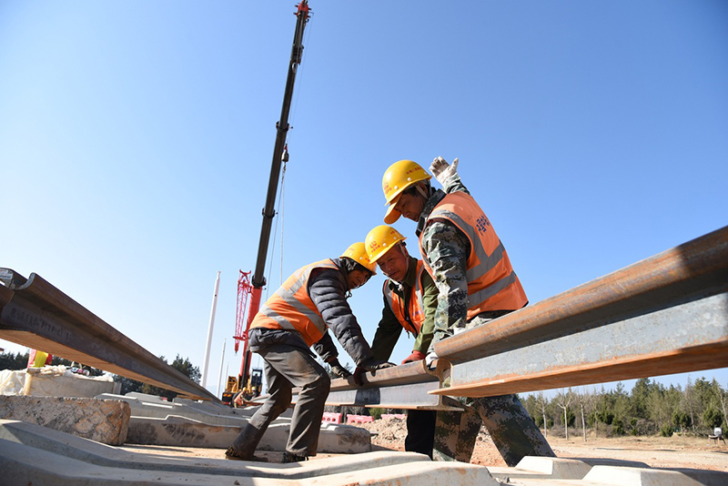 Los trabajadores de la construcción pavimentan las vías del tren para el primer tren turístico del mundo con una vista panorámica de la monta?a en Lijiang, provincia de Yunan. [Foto: proporcionada a chinadaily.com.cn]