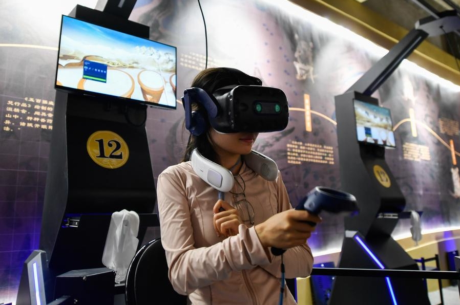 Una visitante usa un equipo de realidad virtual para visitar las Grutas de Mogao en Dunhuang, en la provincia noroccidental china de Gansu, el 22 de julio de 2024. (Xinhua/Lang Bingbing)